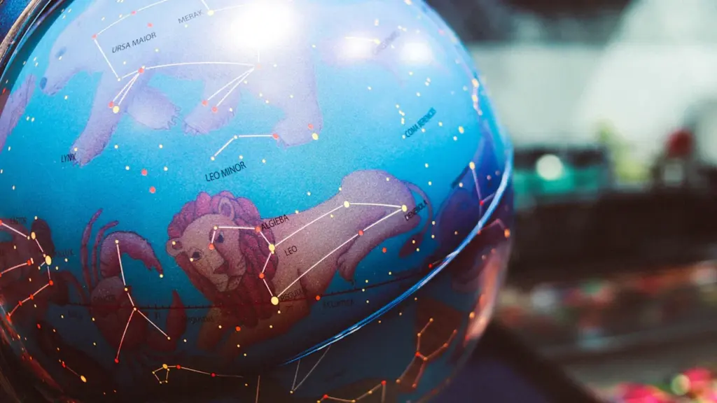 Zilais debess globuss ar zvaigznājiem un zodiaka zīmju attēliem tumšā fonā.